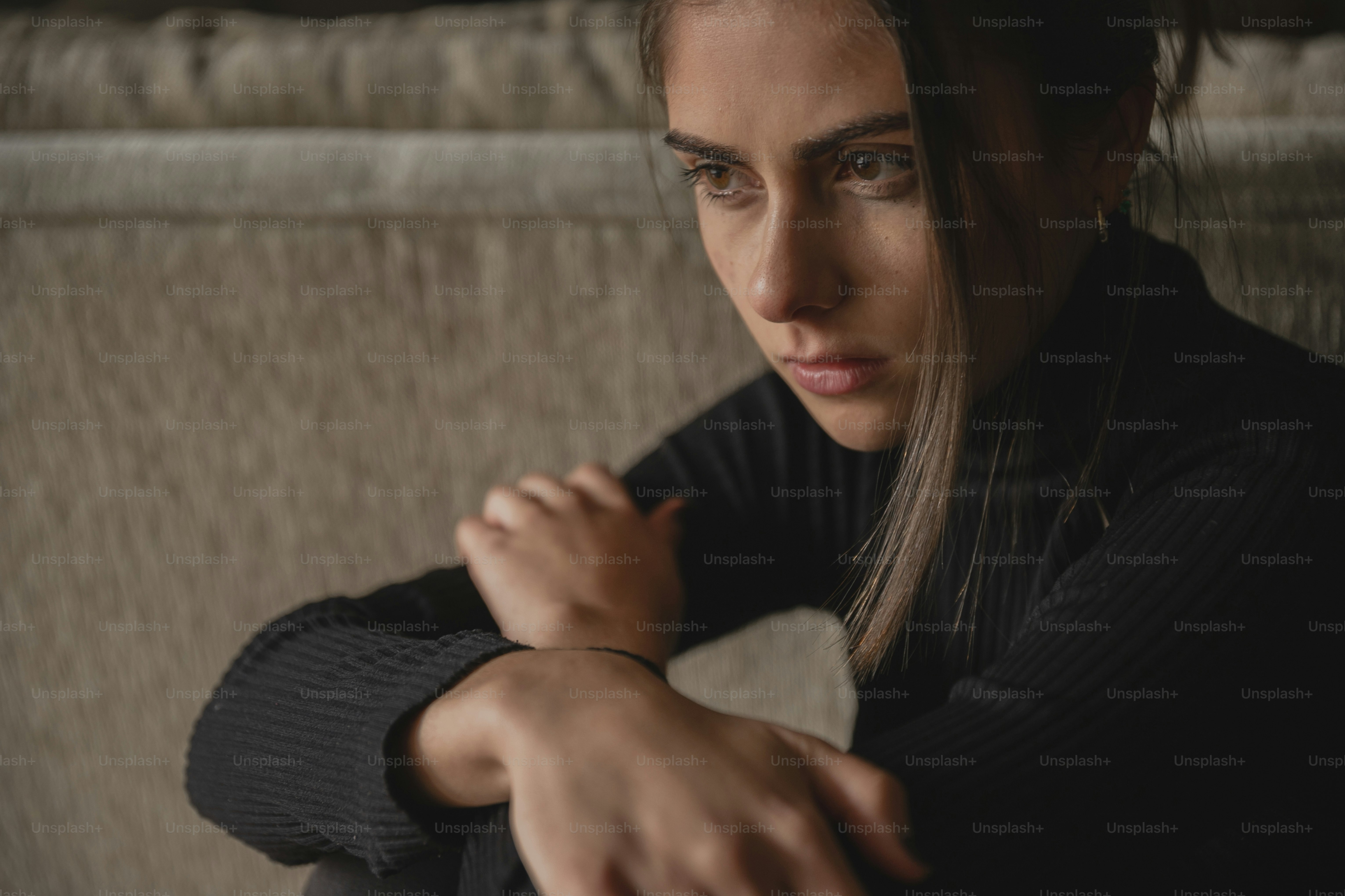 a woman sitting on a couch with her arms crossed