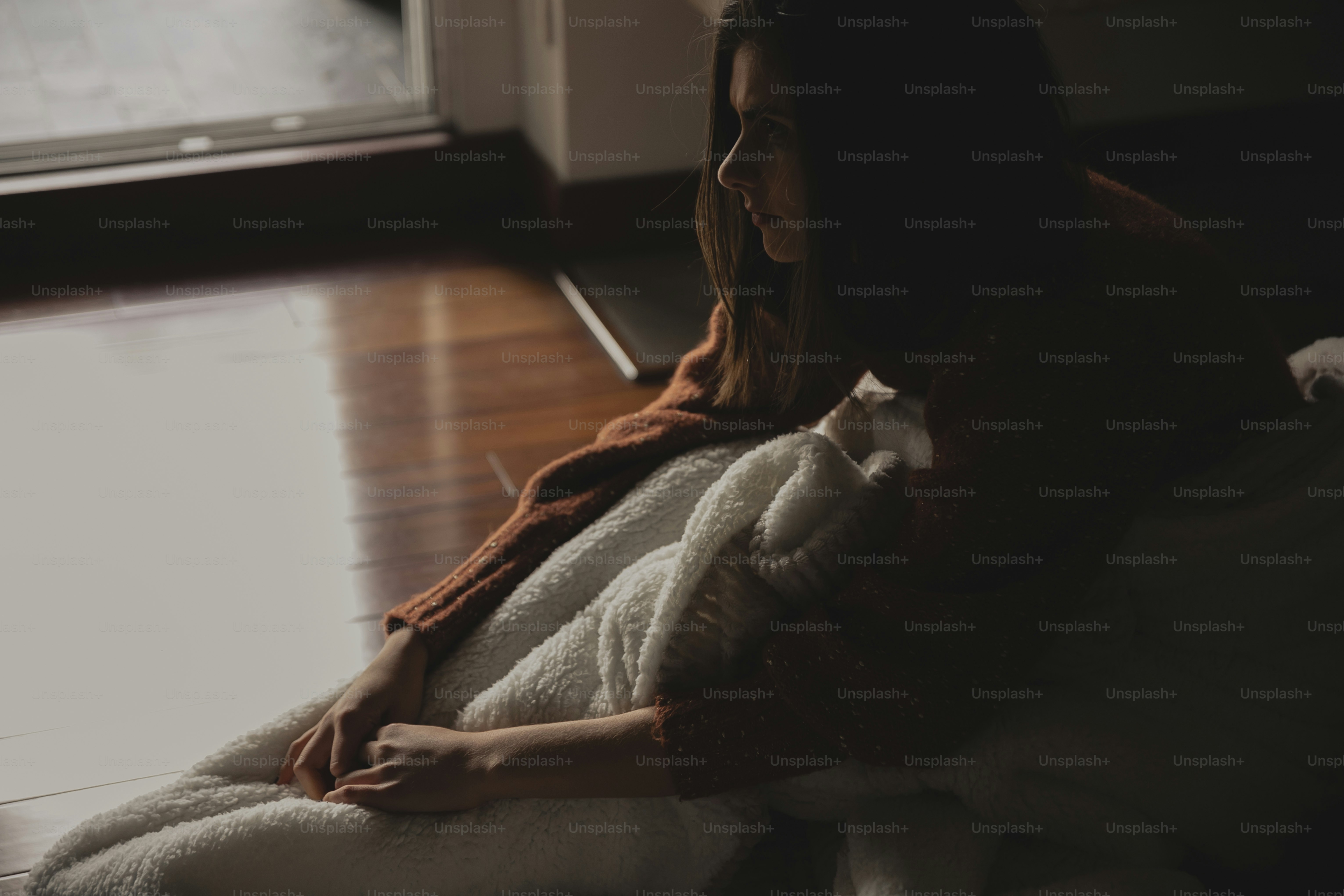 una mujer sentada en el suelo usando una computadora portátil