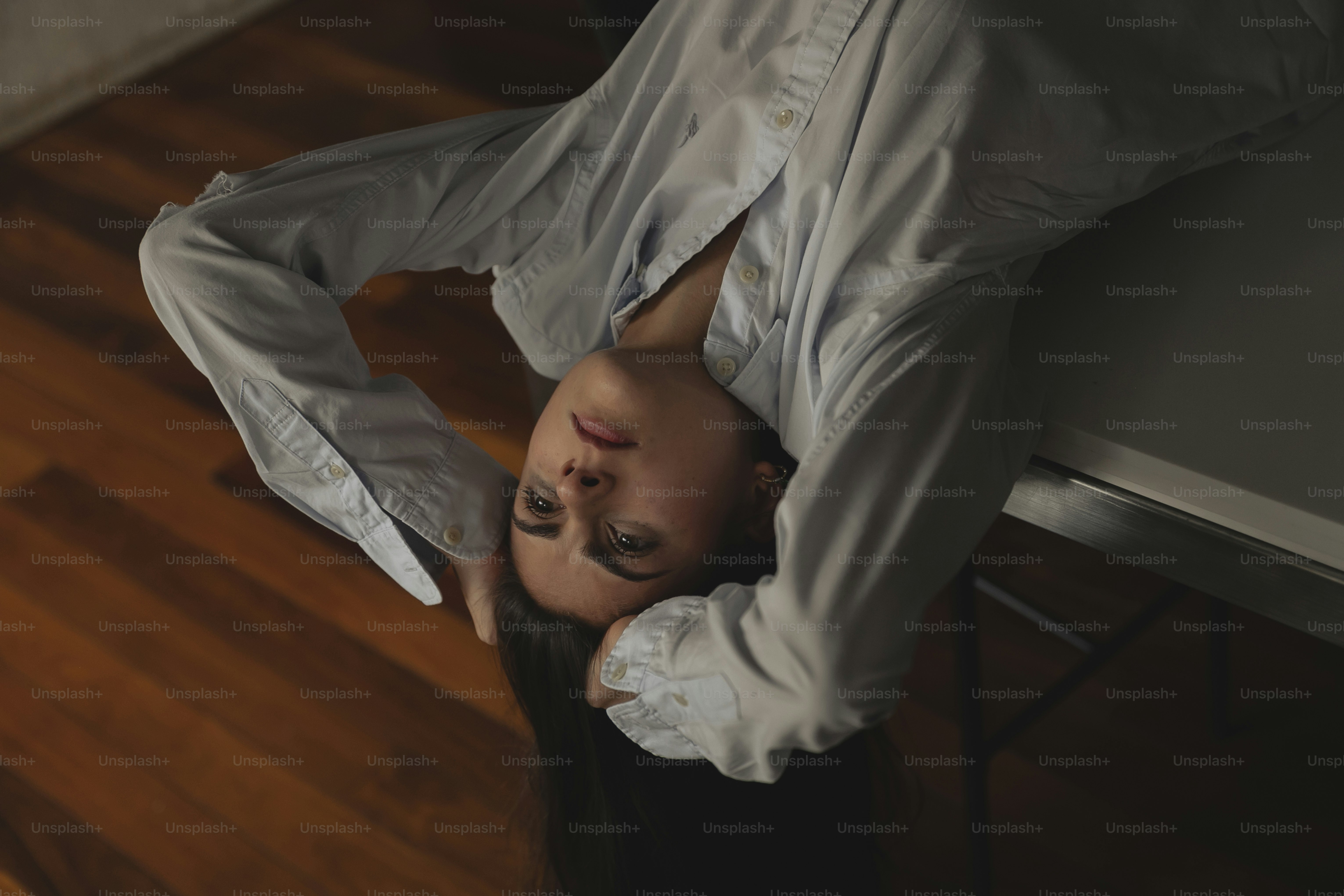 a woman in a white shirt is standing on a wooden floor