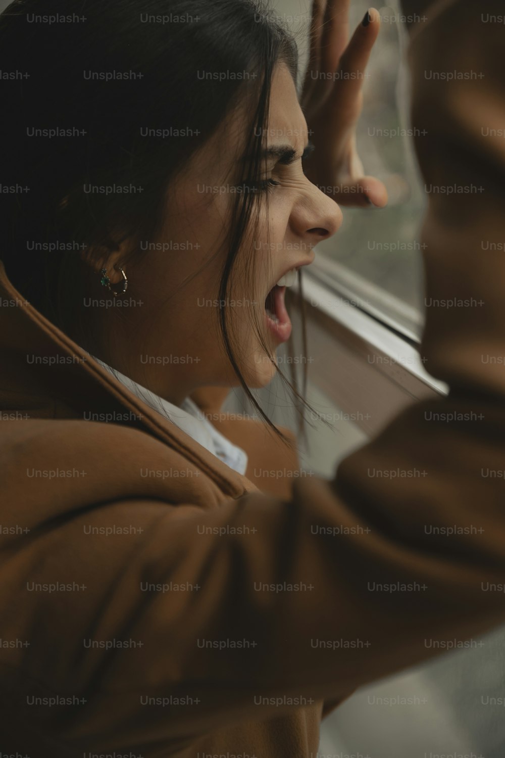 a woman with her mouth open looking out a window