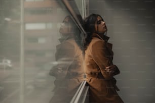 a woman in a trench coat looking out a window