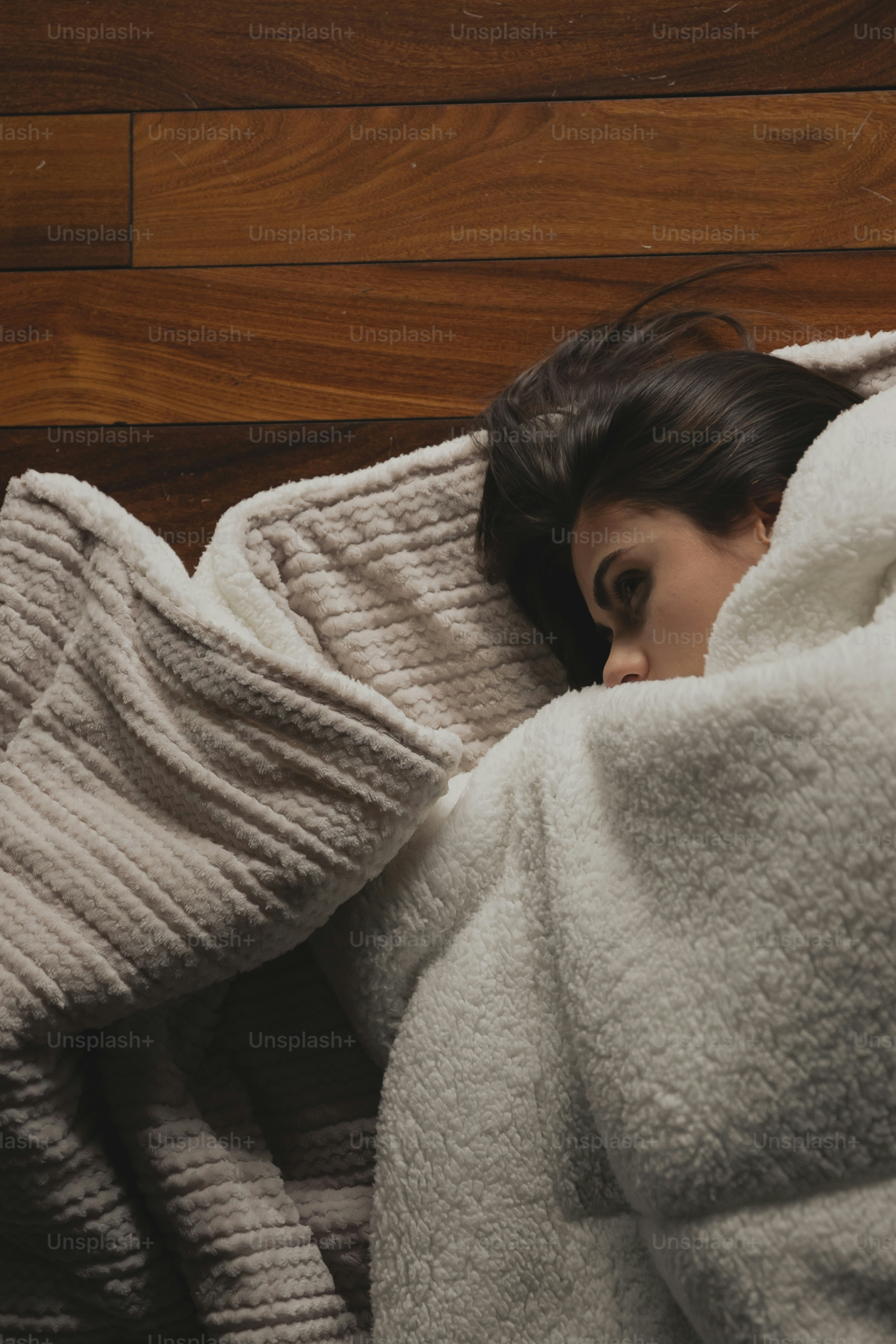 a woman wrapped in a blanket on a bed