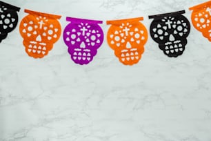 a string of paper skulls hanging from a line
