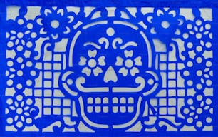 a blue paper cut of a skull with flowers