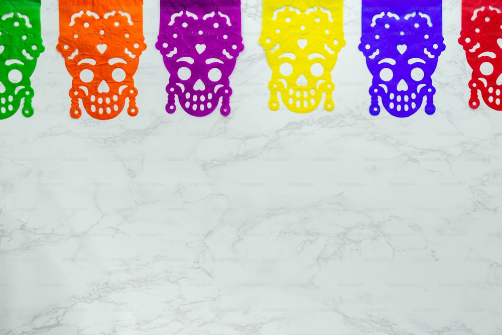 a row of colorful skulls on a marble surface