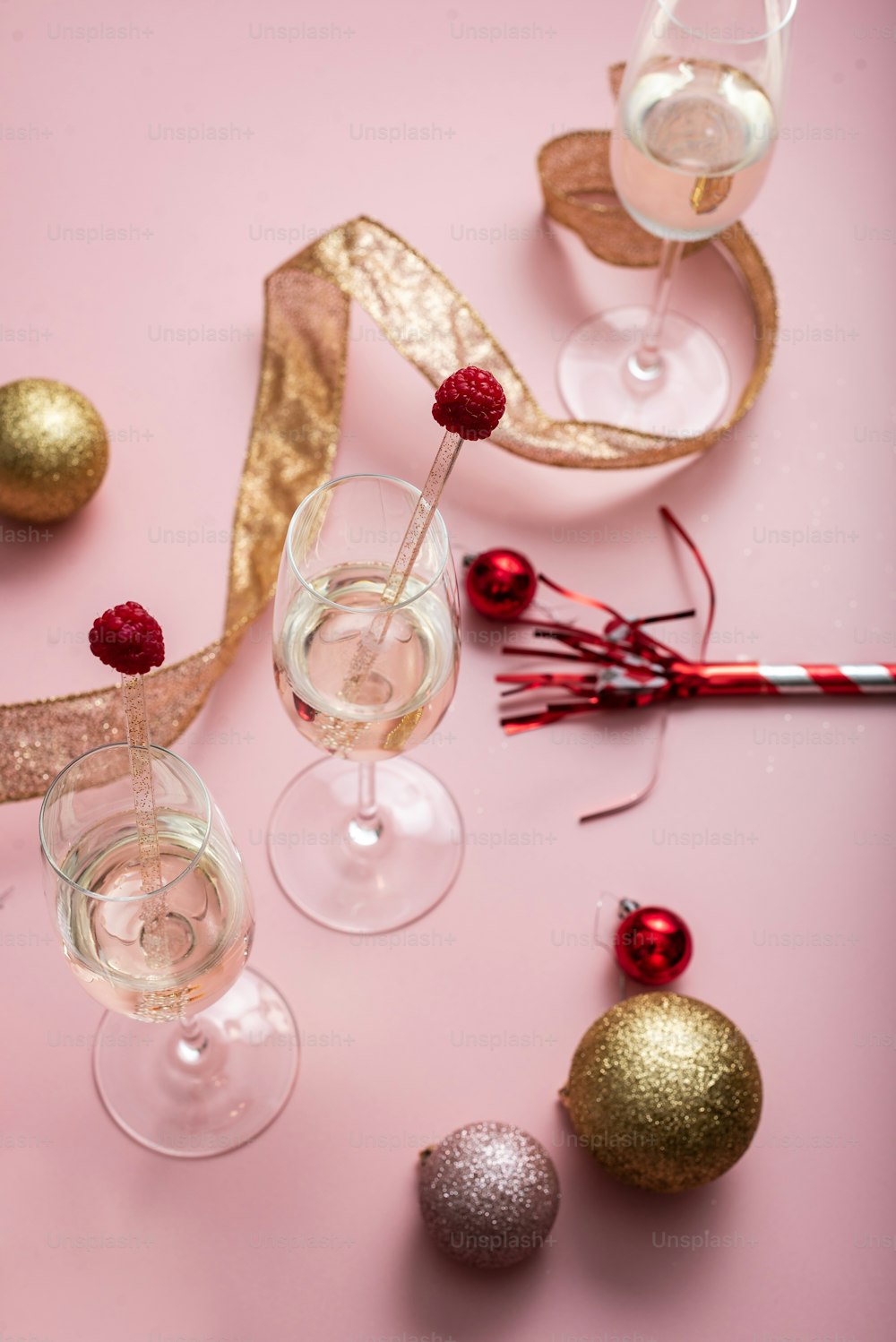 a pink table topped with two wine glasses filled with champagne