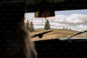 a woman driving a car down a dirt road