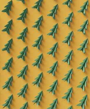 a group of green paper christmas trees on a yellow background