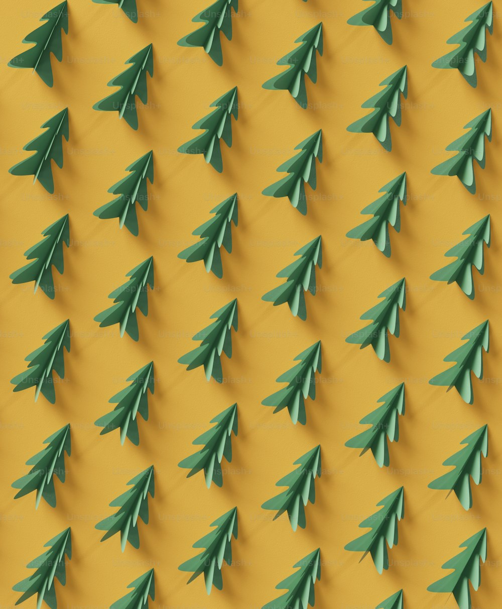 a group of green paper christmas trees on a yellow background