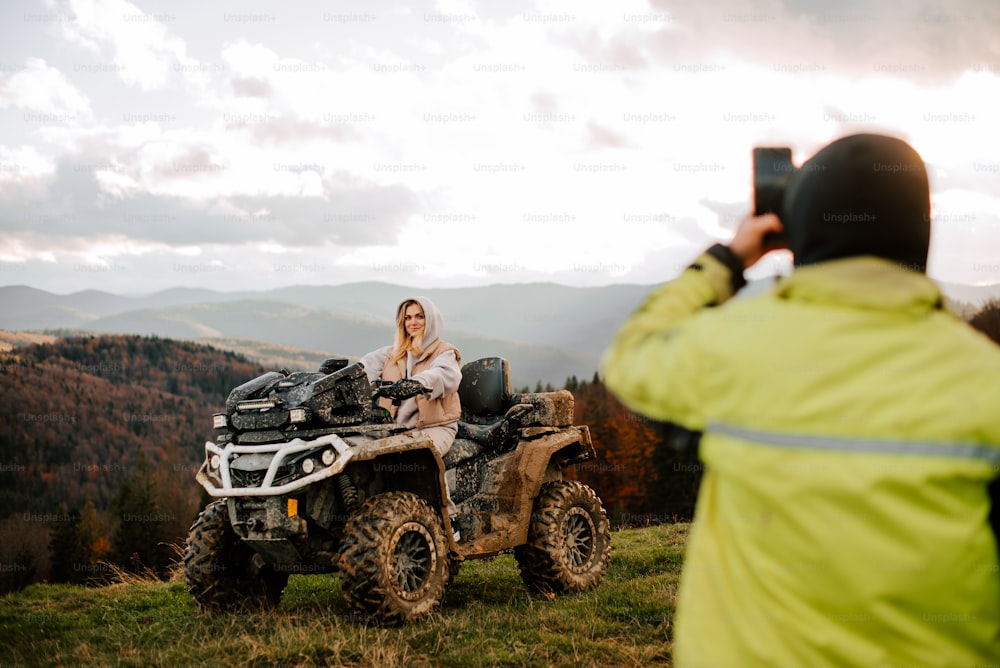 a man taking a picture of a woman riding an atv