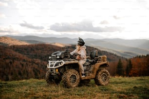 a man sitting on a four wheeler in the mountains