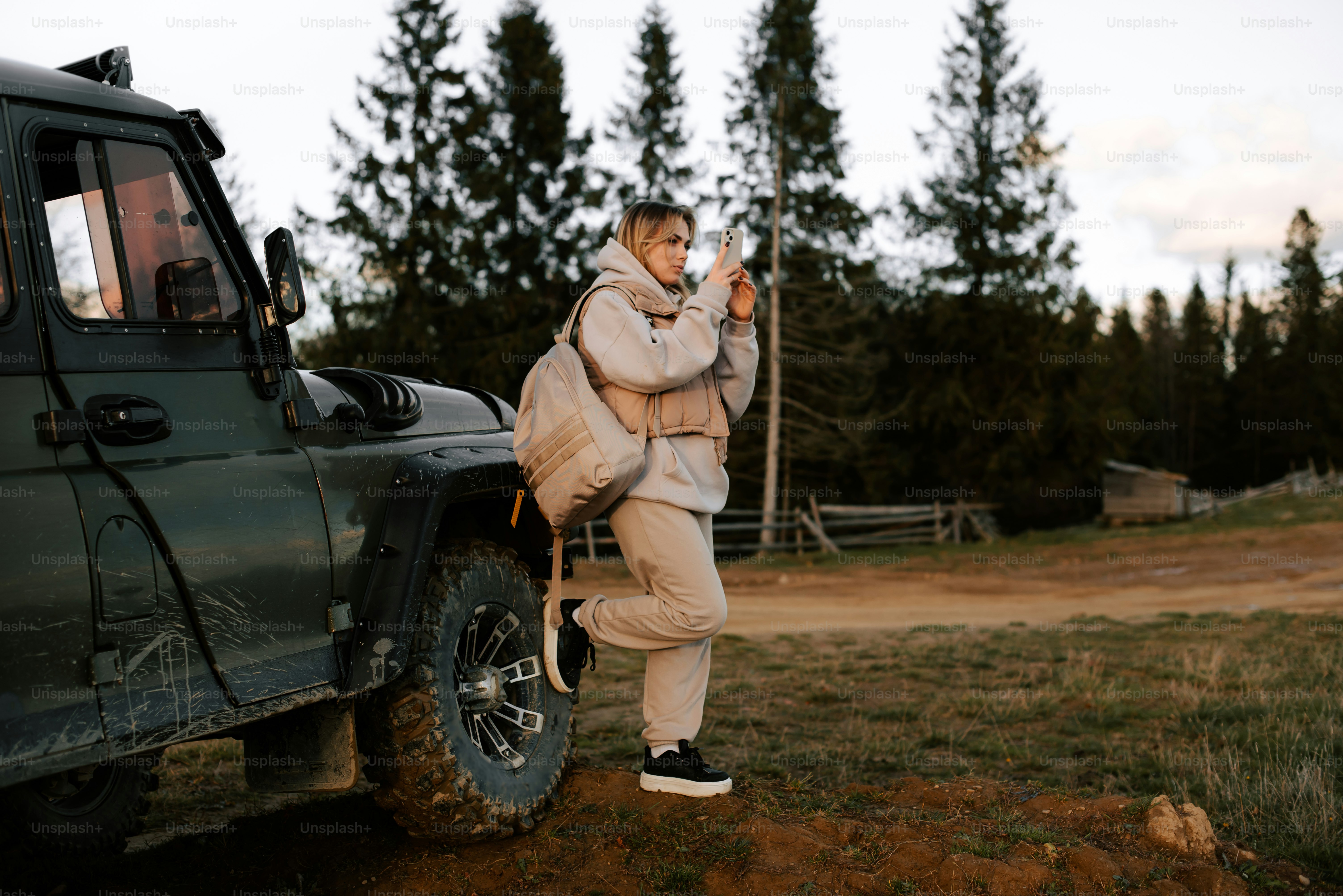 a woman standing next to a green jeep