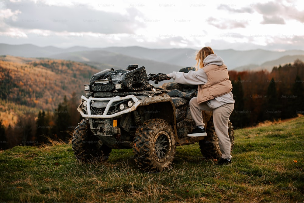 a woman sitting on a four - wheeler in the mountains