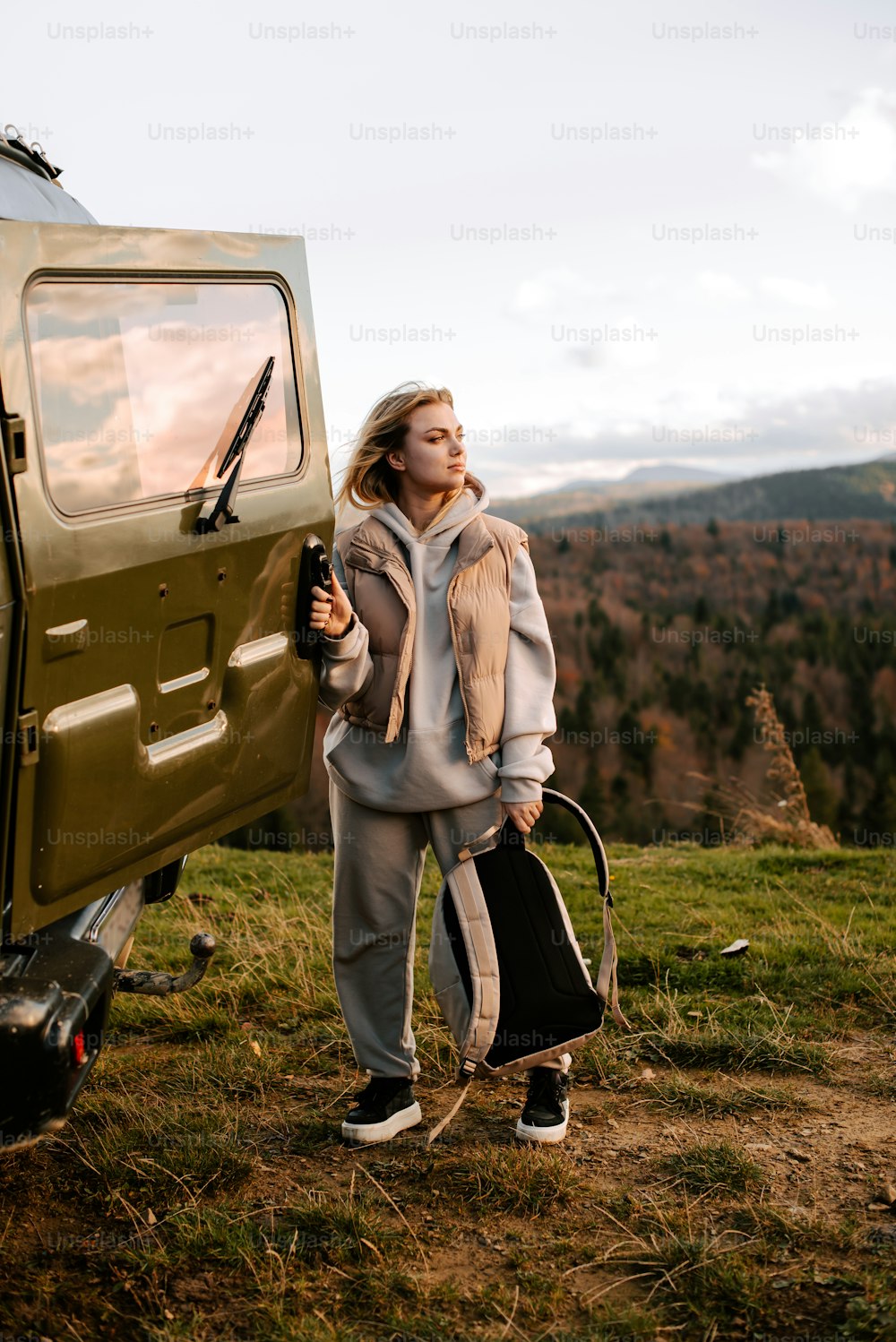 a woman standing next to a green vehicle