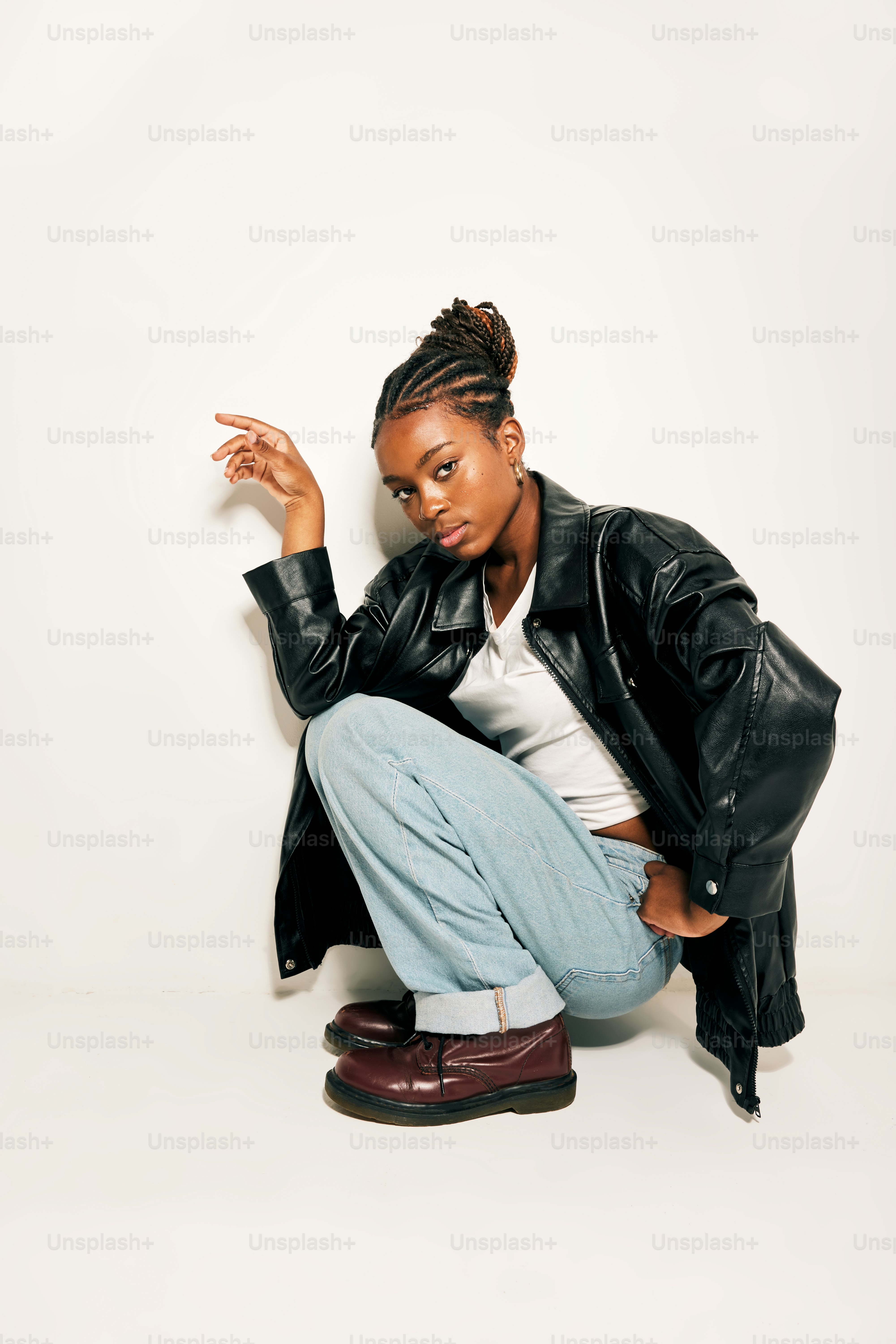 A woman sitting on the ground in a black jacket photo – Denim jeans ...