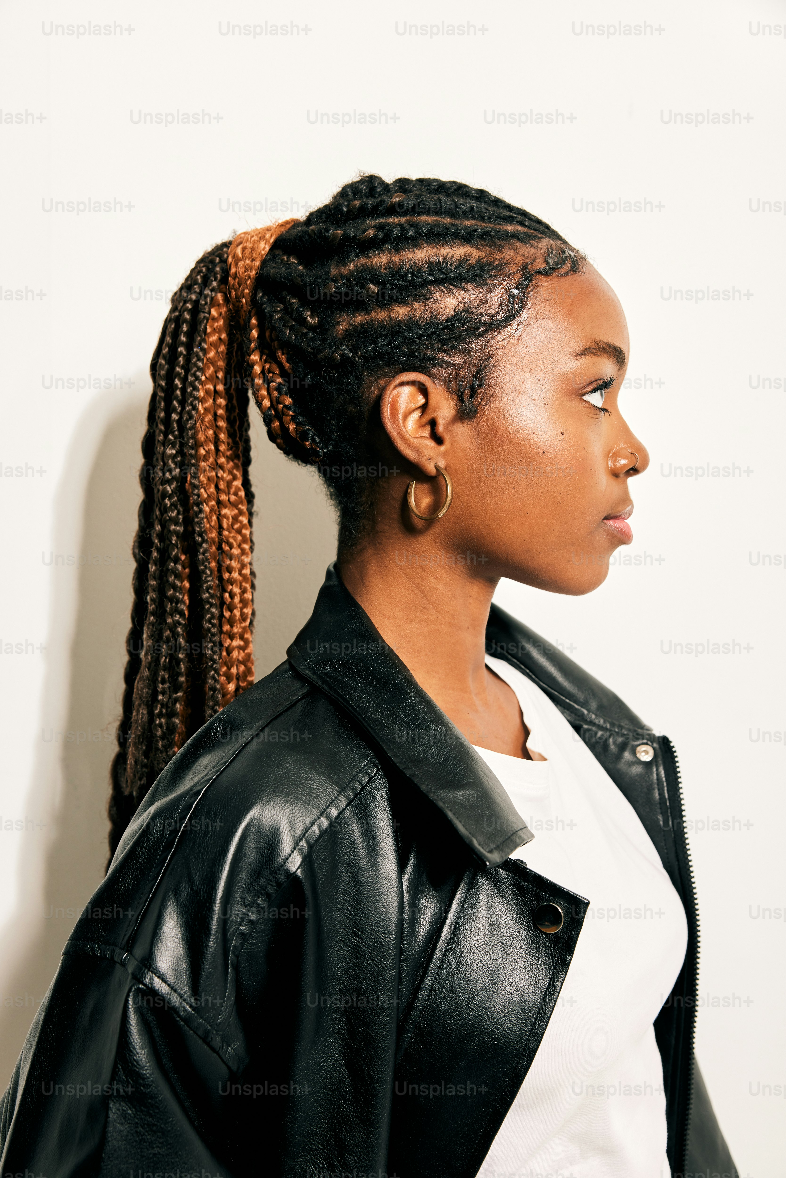 una mujer con una chaqueta de cuero negro y trenzas