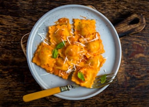 a white plate topped with ravioli and cheese