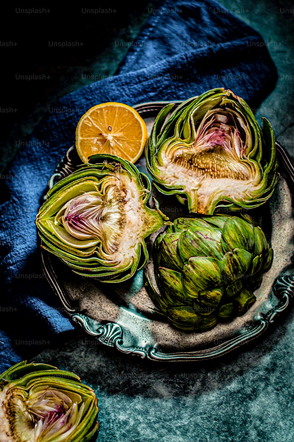 a plate of artichokes on a blue cloth