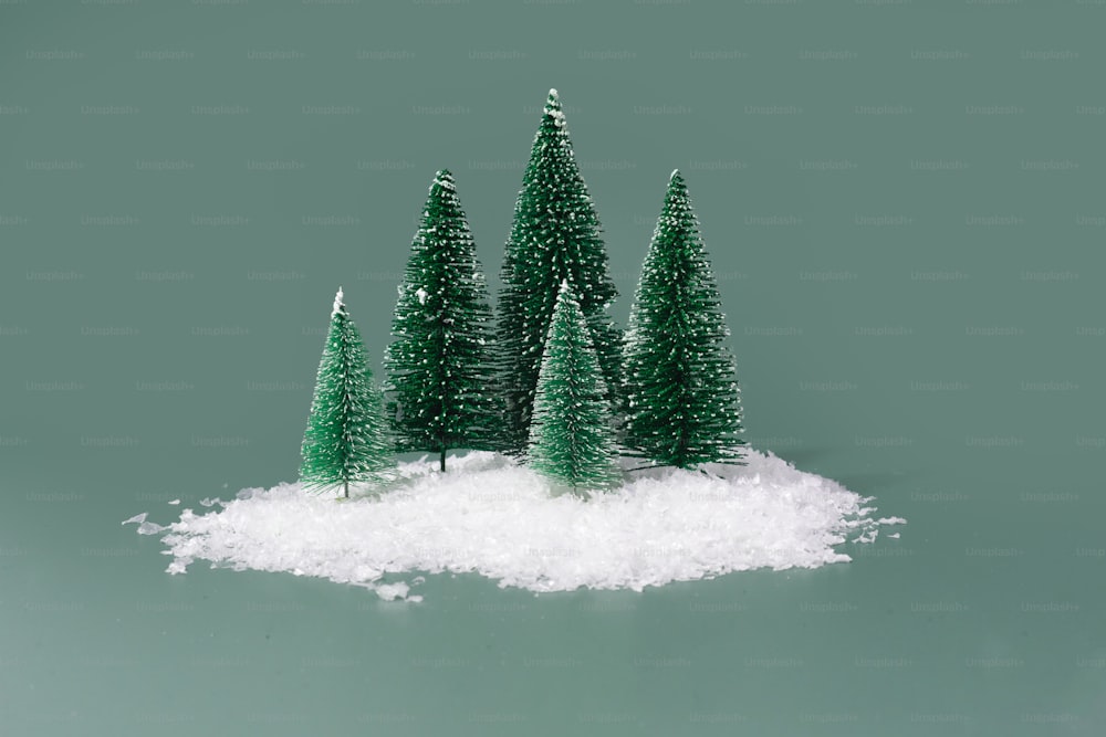 a group of small trees sitting on top of a pile of snow