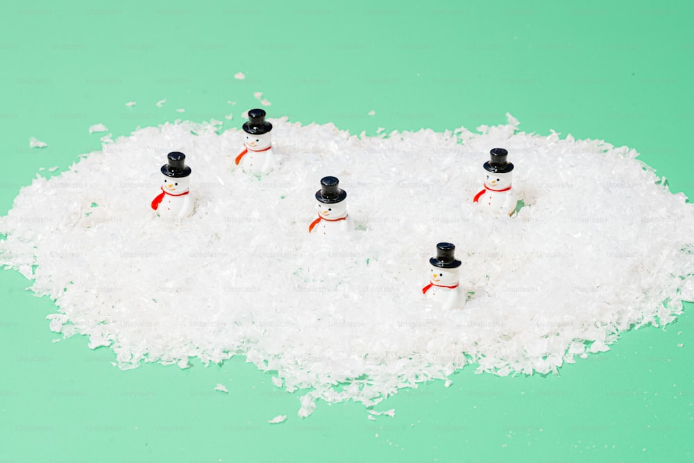 a group of snowmen sitting on top of a pile of snow