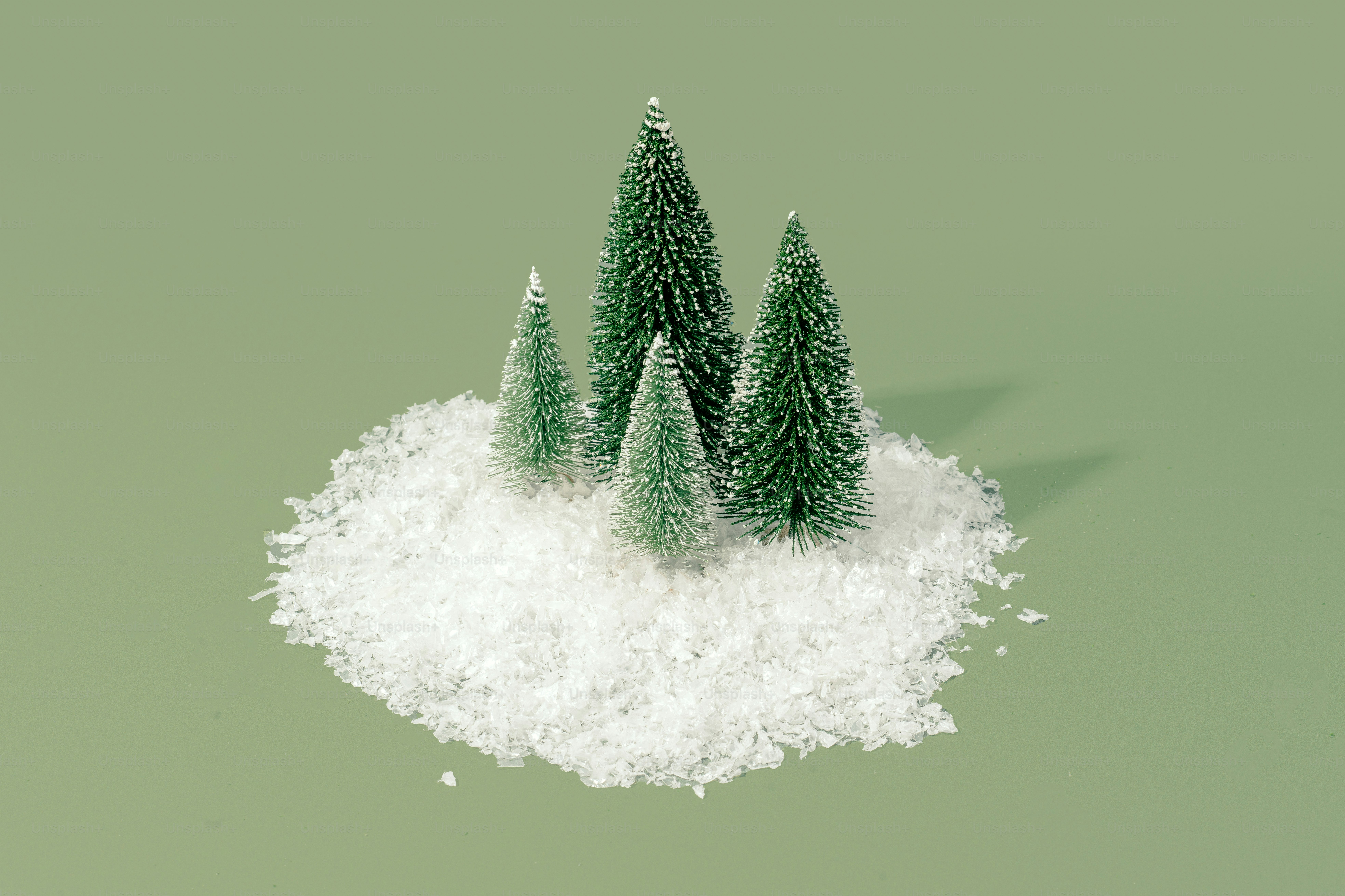 three small christmas trees sitting on top of a pile of snow