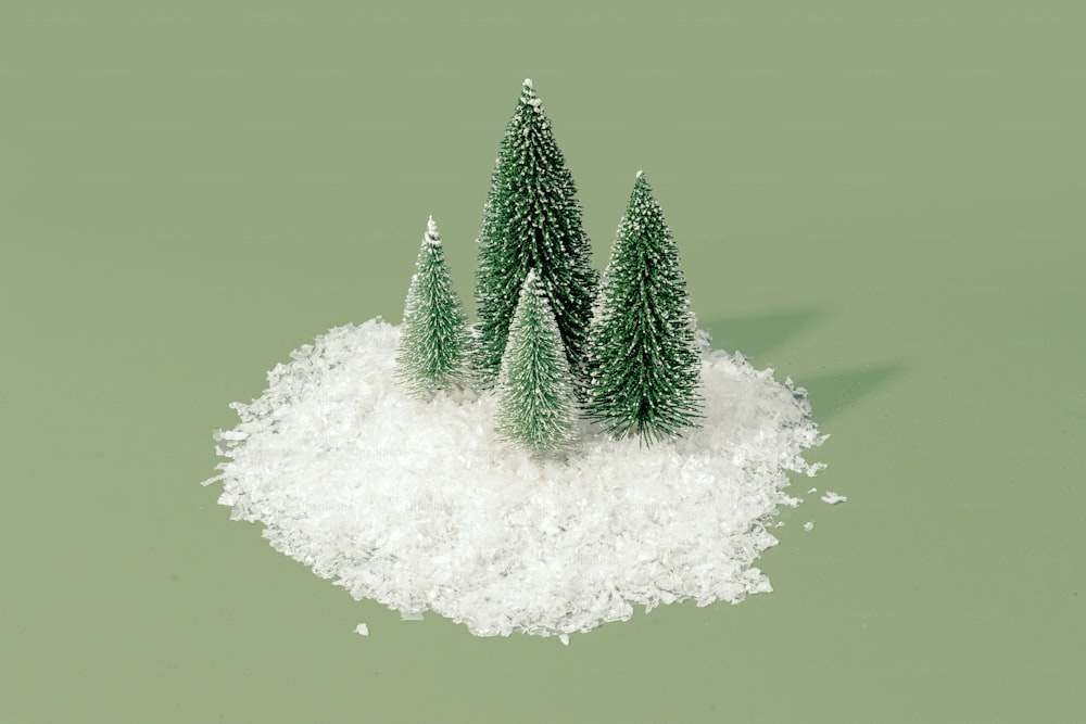 three small christmas trees sitting on top of a pile of snow