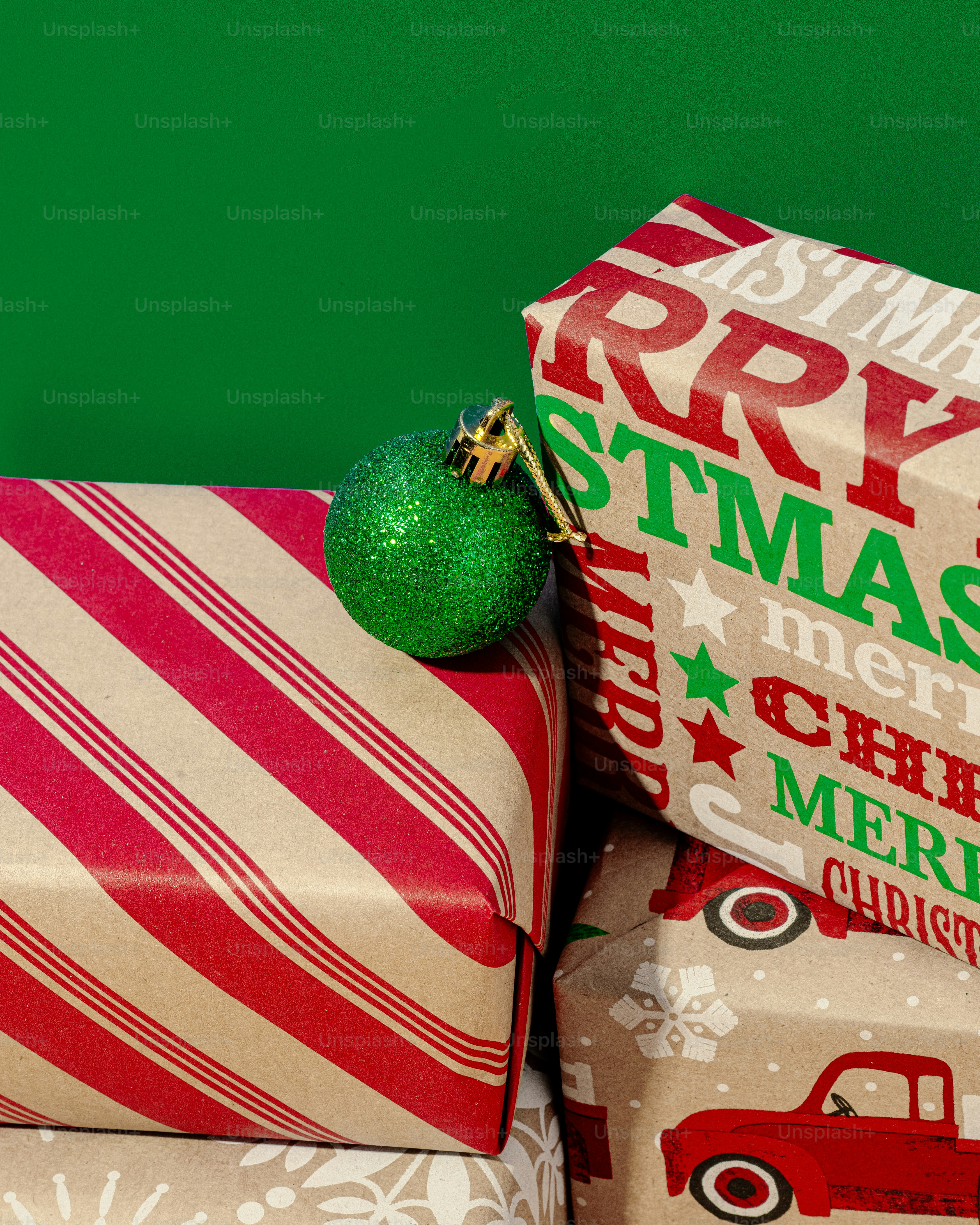 Presents wrapped in wrapping paper with a green ornament on top photo