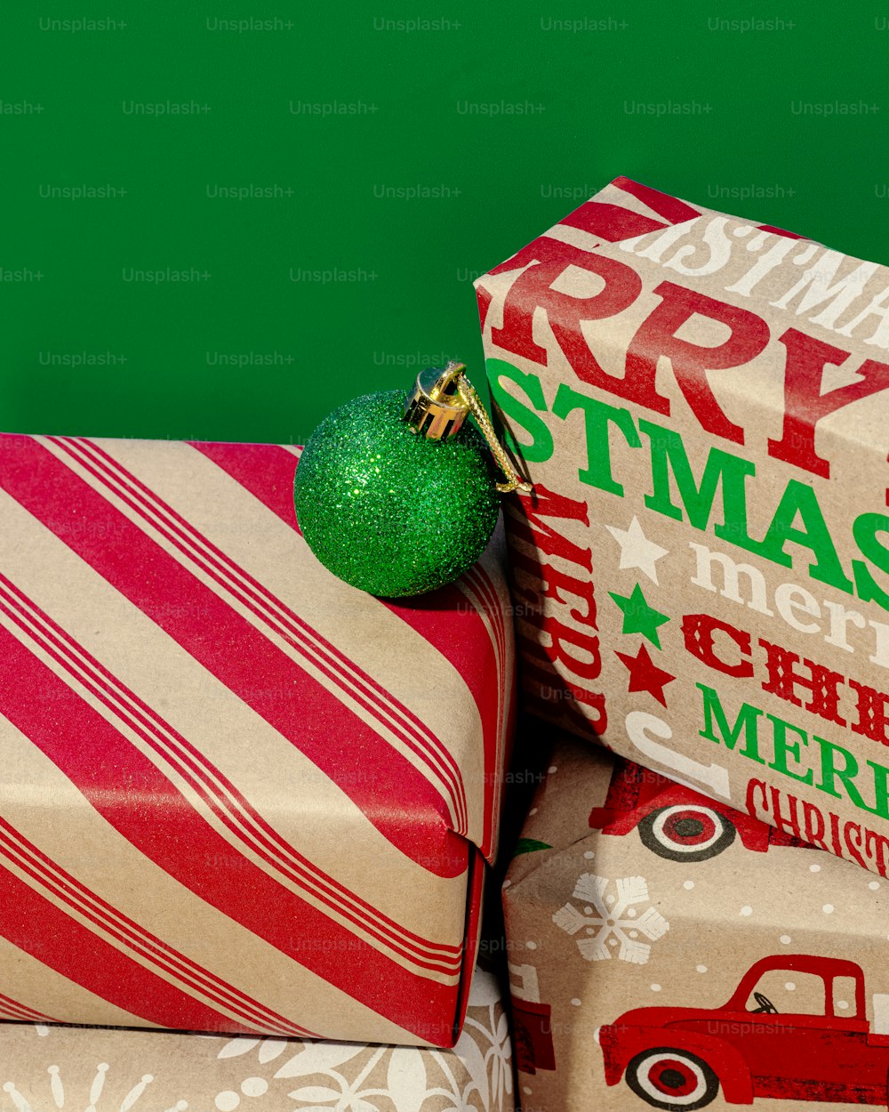 Geschenke eingewickelt in Geschenkpapier mit grünem Ornament oben drauf