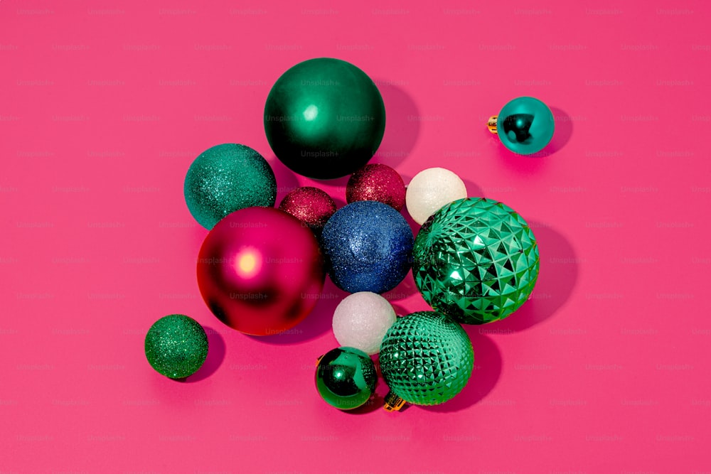 a group of christmas ornaments on a pink background