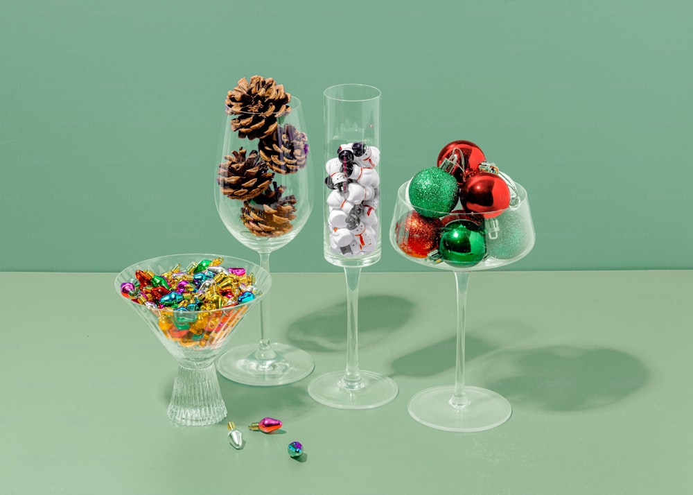 three wine glasses filled with candy and pine cones
