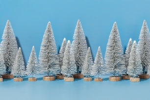 a row of silver christmas trees on a blue background