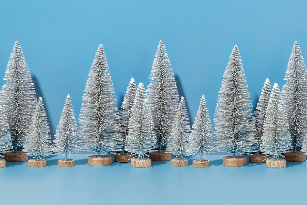 a row of silver christmas trees on a blue background