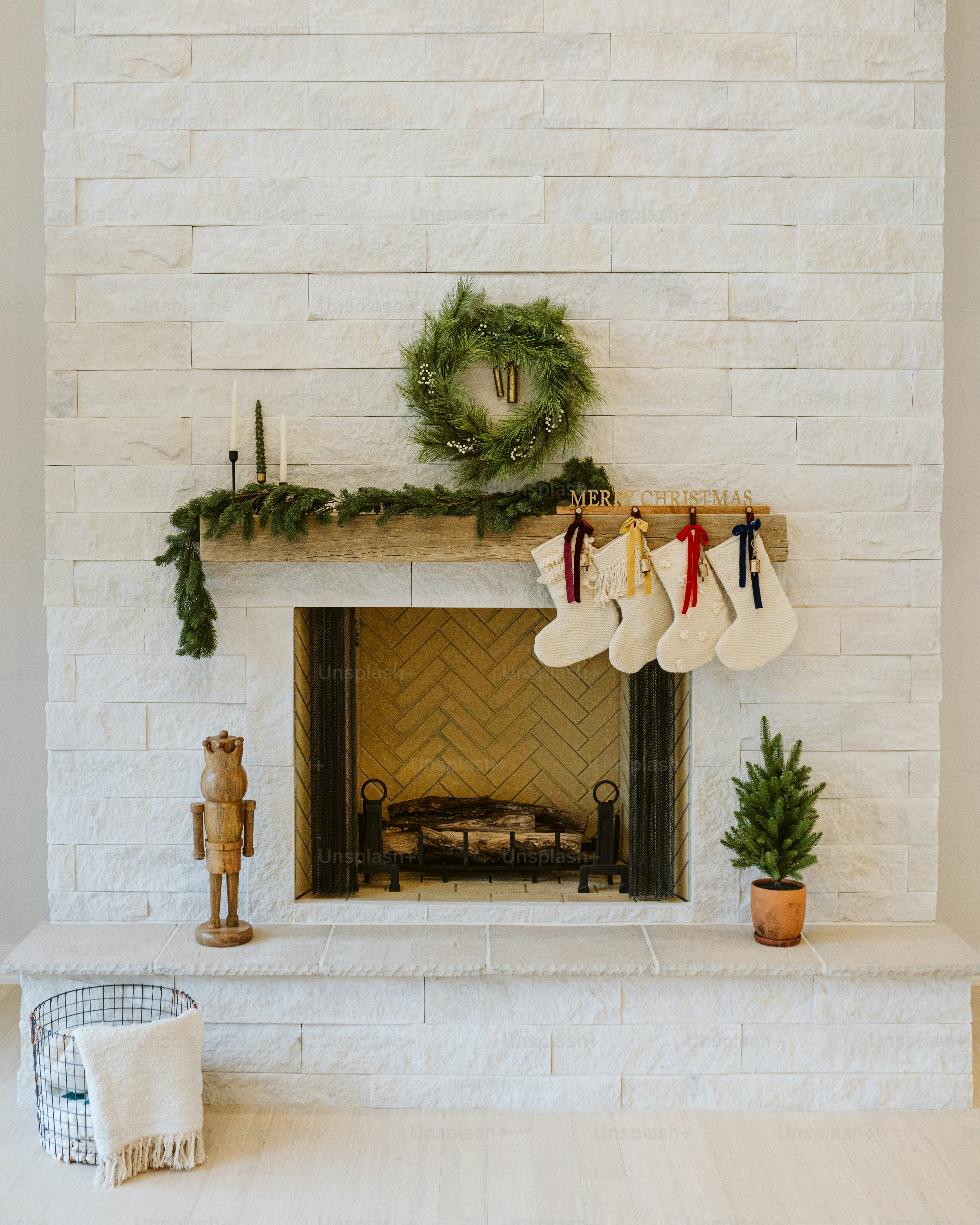 a fireplace decorated for christmas with stockings and a wreath