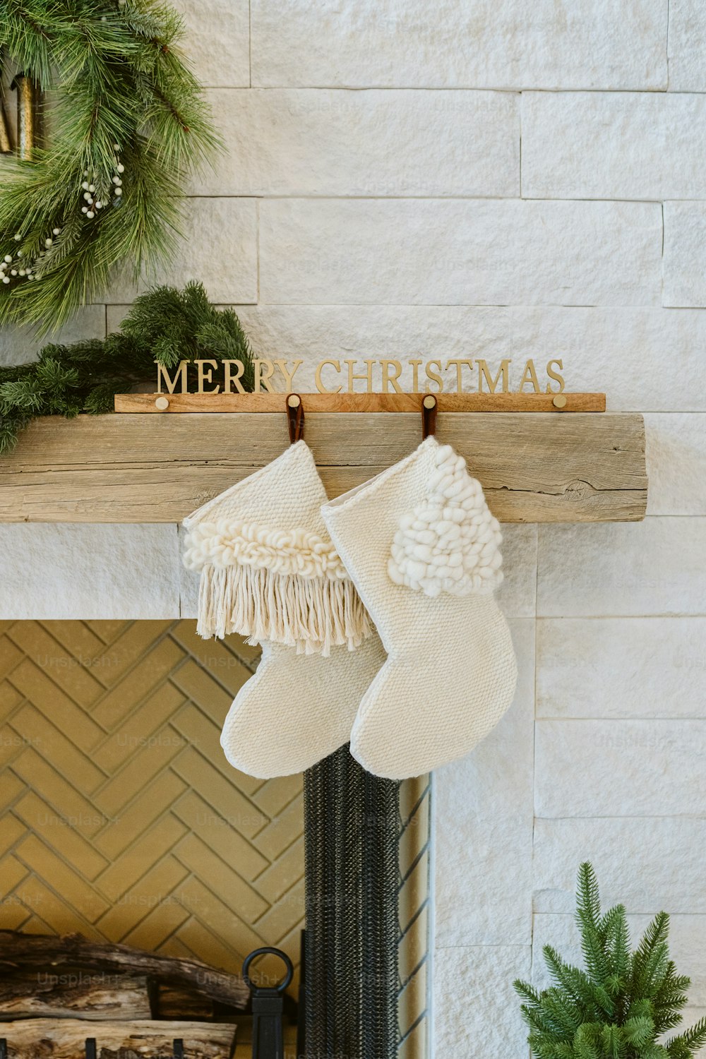 a fireplace with stockings and a merry christmas sign