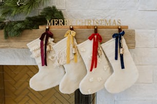 stockings hanging from a mantel with a merry christmas sign
