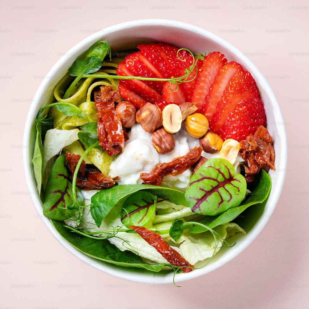 a white bowl filled with a salad and fruit