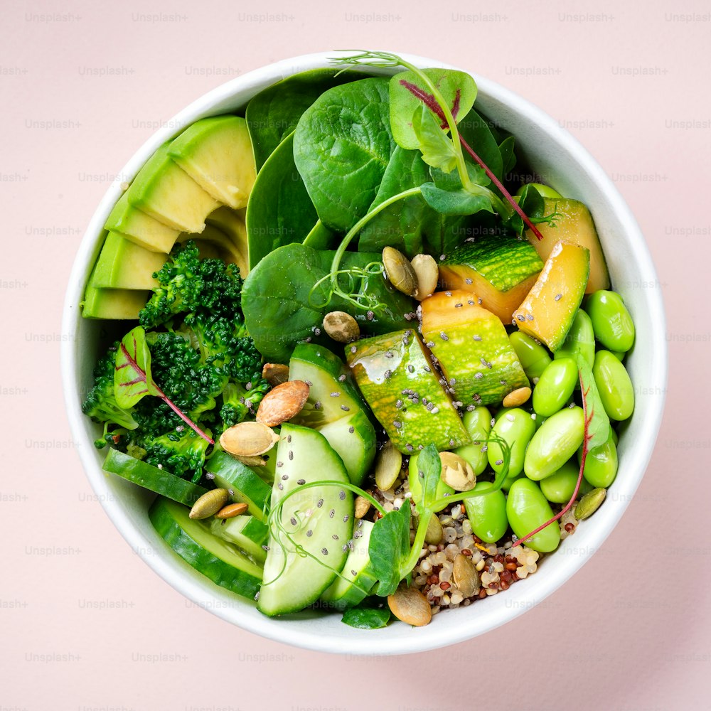 a white bowl filled with green vegetables and nuts