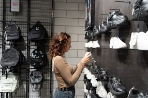 a woman looking at shoes on display in a store