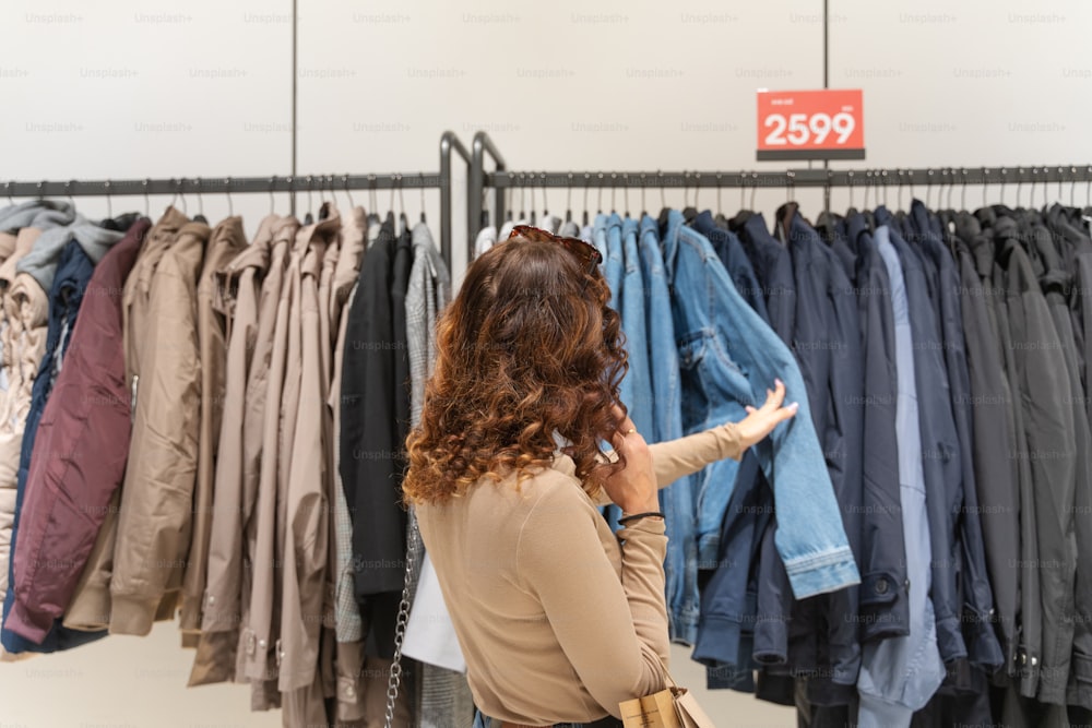 a woman standing in front of a rack of clothes