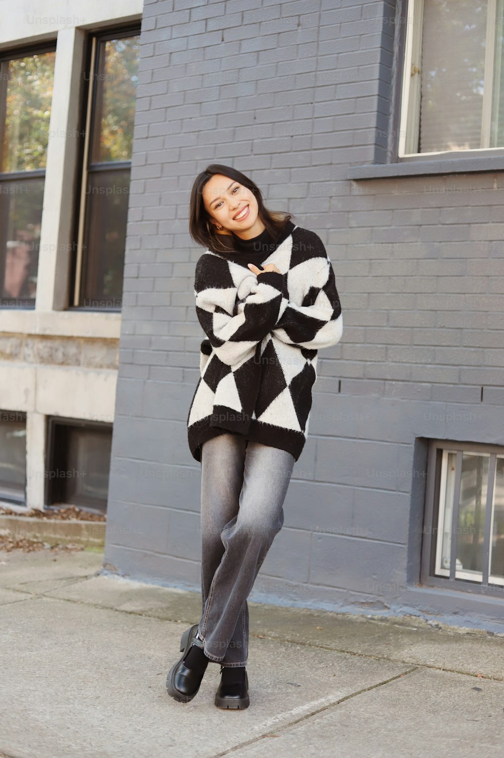 a woman in a black and white sweater posing for a picture