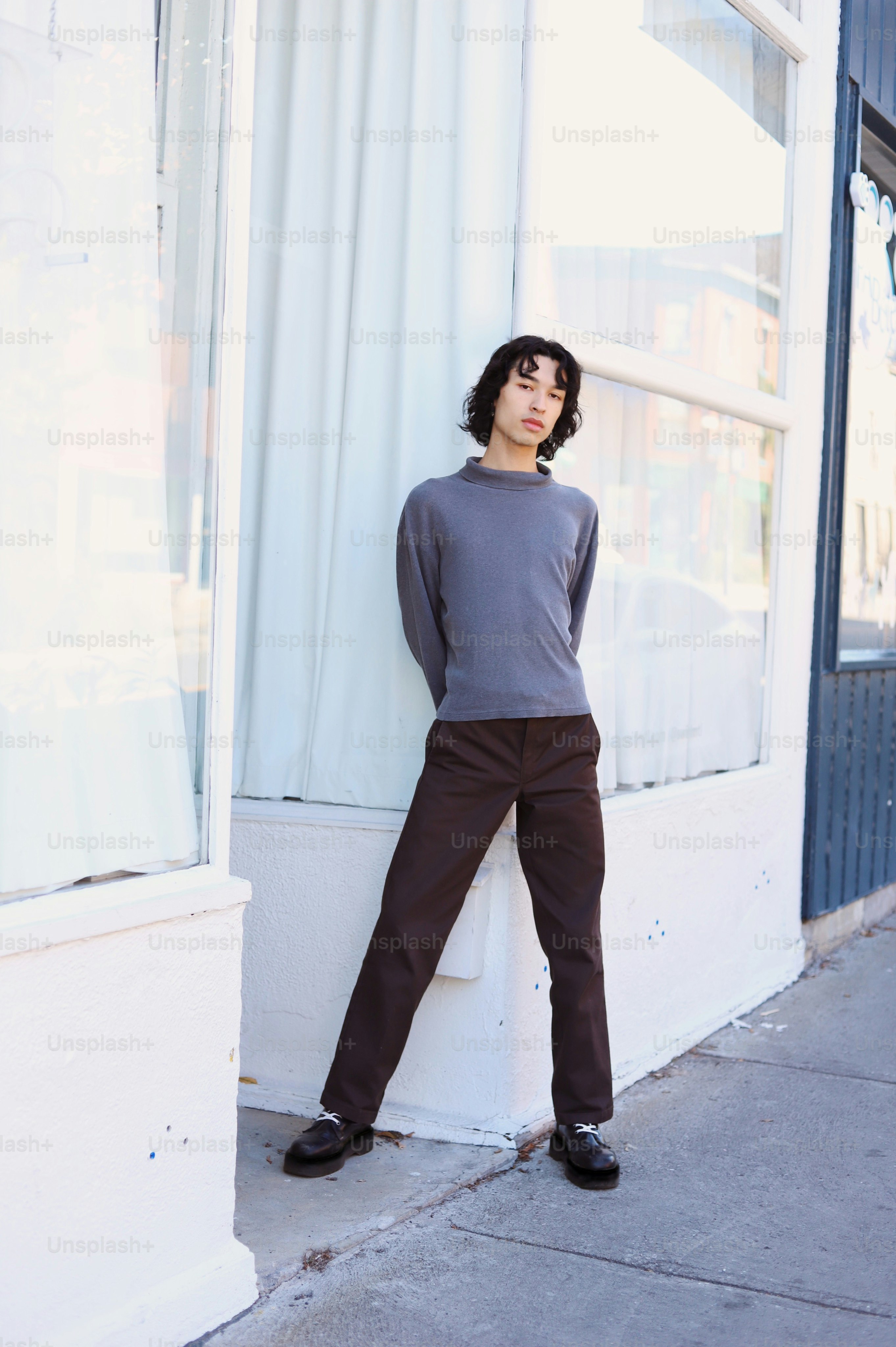 a woman leaning against a window on a sidewalk