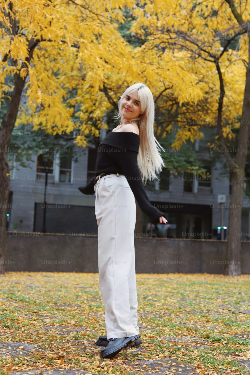 a woman in a black top and white pants