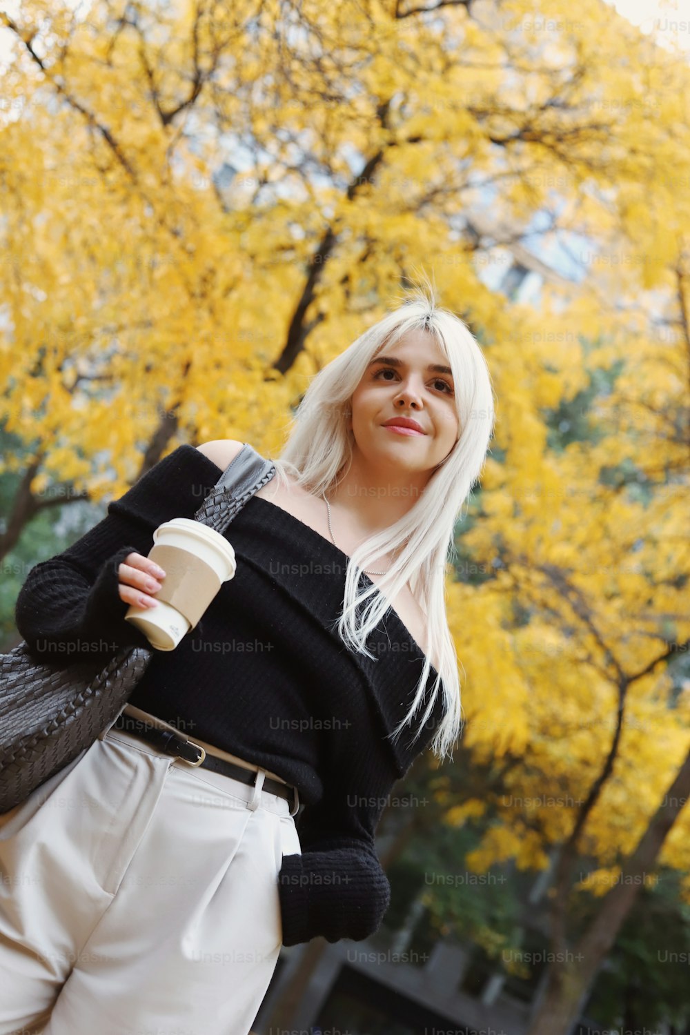 Una mujer de pelo blanco sostiene una taza de café