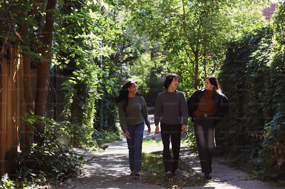three people walking down a path in the woods