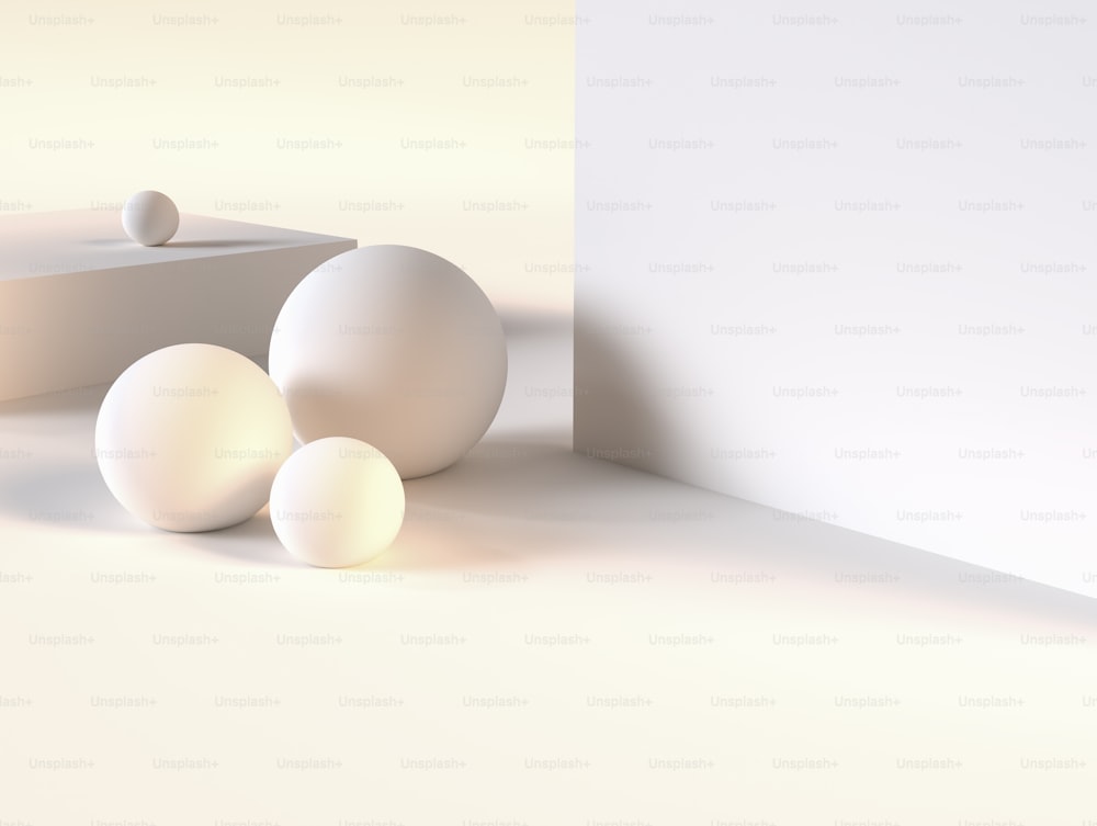 a group of three white balls sitting next to a wall