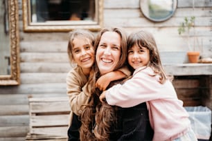a woman and two girls hugging each other