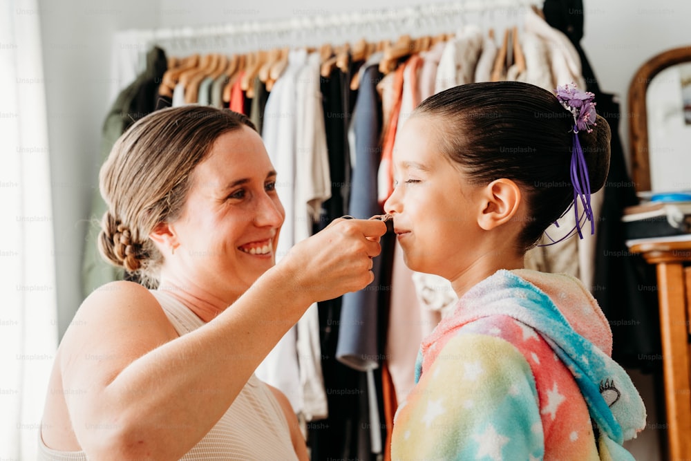 a woman is helping another woman get ready for her wedding