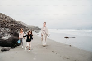 un gruppo di persone che camminano lungo una spiaggia vicino all'oceano