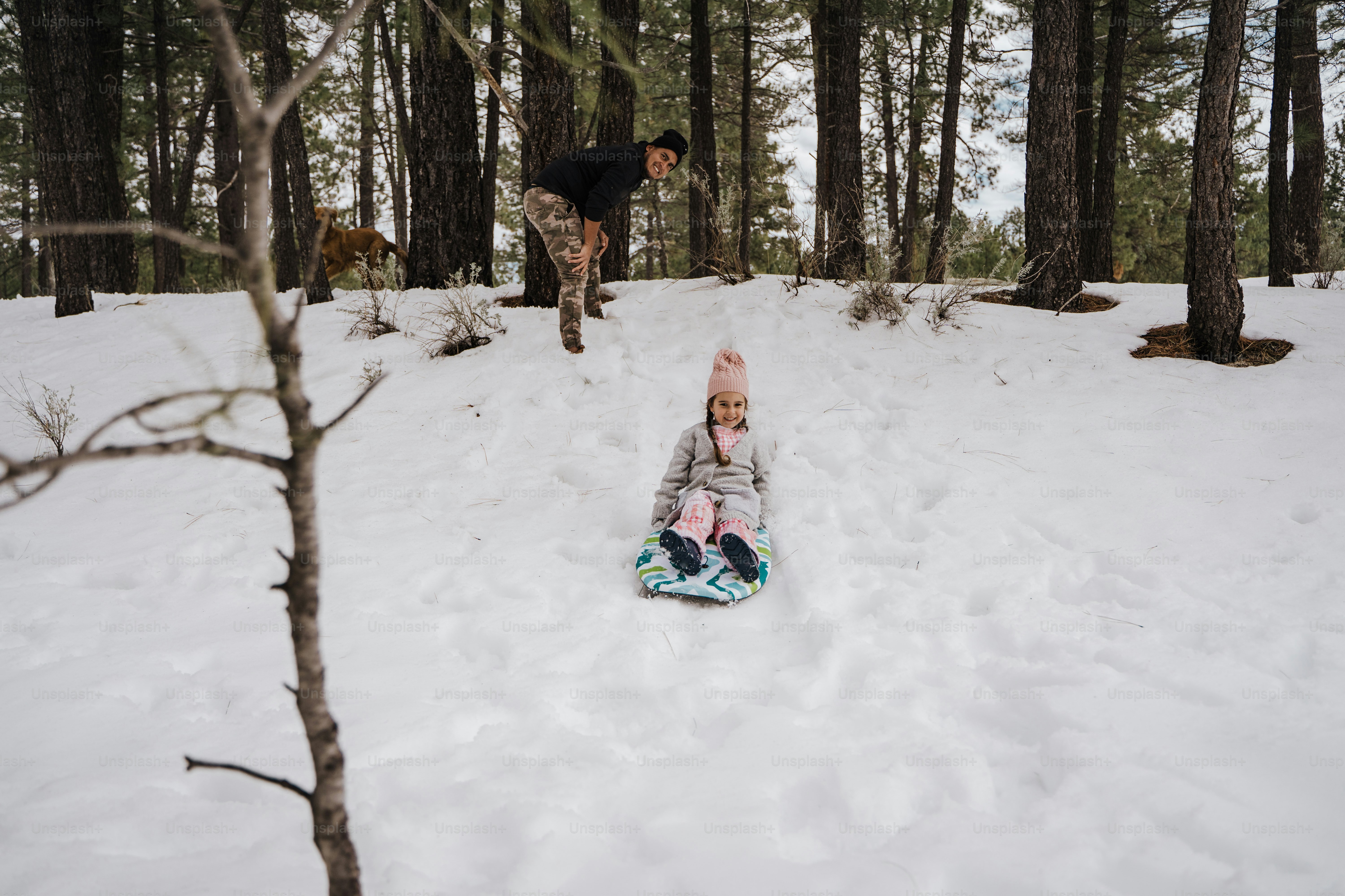 a small child laying in the snow on a snowboard