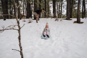 a small child laying in the snow on a snowboard